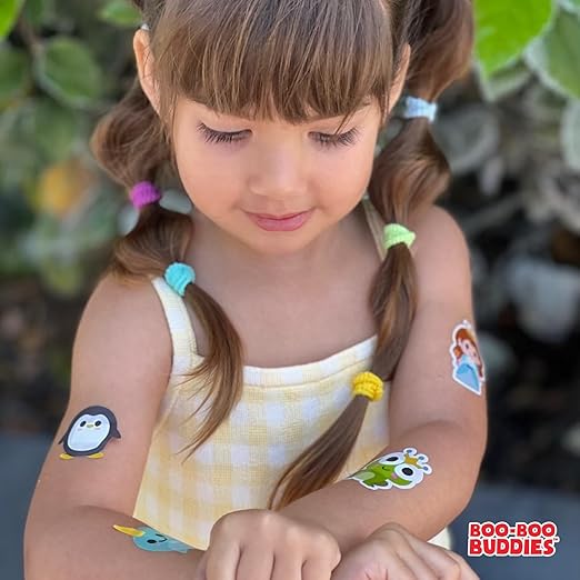 Young child looking at multiple Boo Boo Buddies fun and colorful kids bandages applied on her arms.