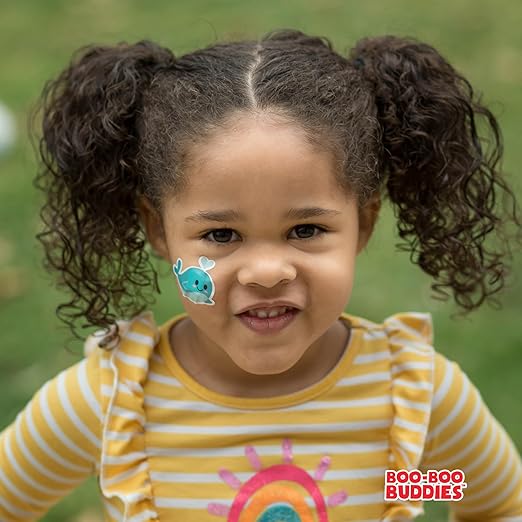 Girl smiling while wearing Boo Boo Buddies kids bandage during playtime.
