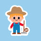 A FARME  WITH BROWN HAT, RED LONG SLEEVE SHIRT AND BLUE OVERALL HOLDING A RAKE 