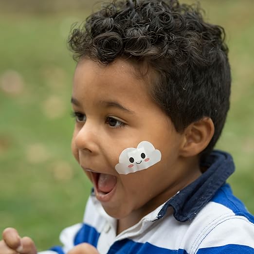 Smiling boy wearing Boo-Boo Buddies® cloud bandage on cheek – fun waterproof kids bandage for face, perfect for playtime or school
