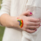 Closeup of Boo Boo Buddies rainbow bandage on hand, bright cheerful bandaid for kids that adds color and comfort to minor scrapes.
