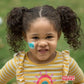 Girl smiling while wearing Boo Boo Buddies kids bandage during playtime.

