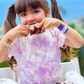 Girl eating messy sandwich wearing Boo-Boo Buddies® Peanut Butter and Jelly bandages on both wrists – cute food-themed bandages for kids with personality
